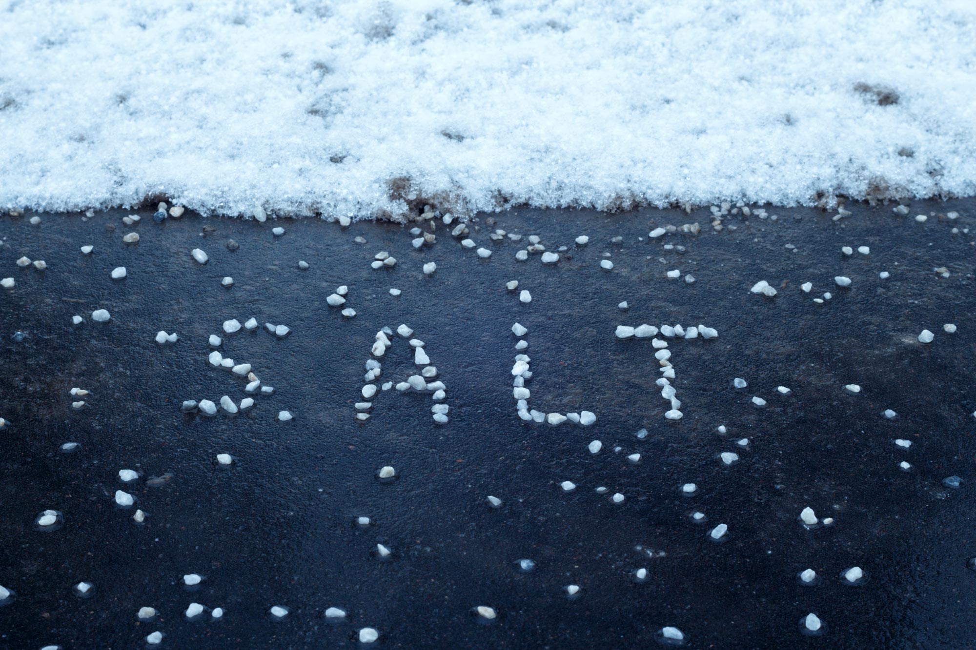 word salt spelled in salt on asphalt with snow