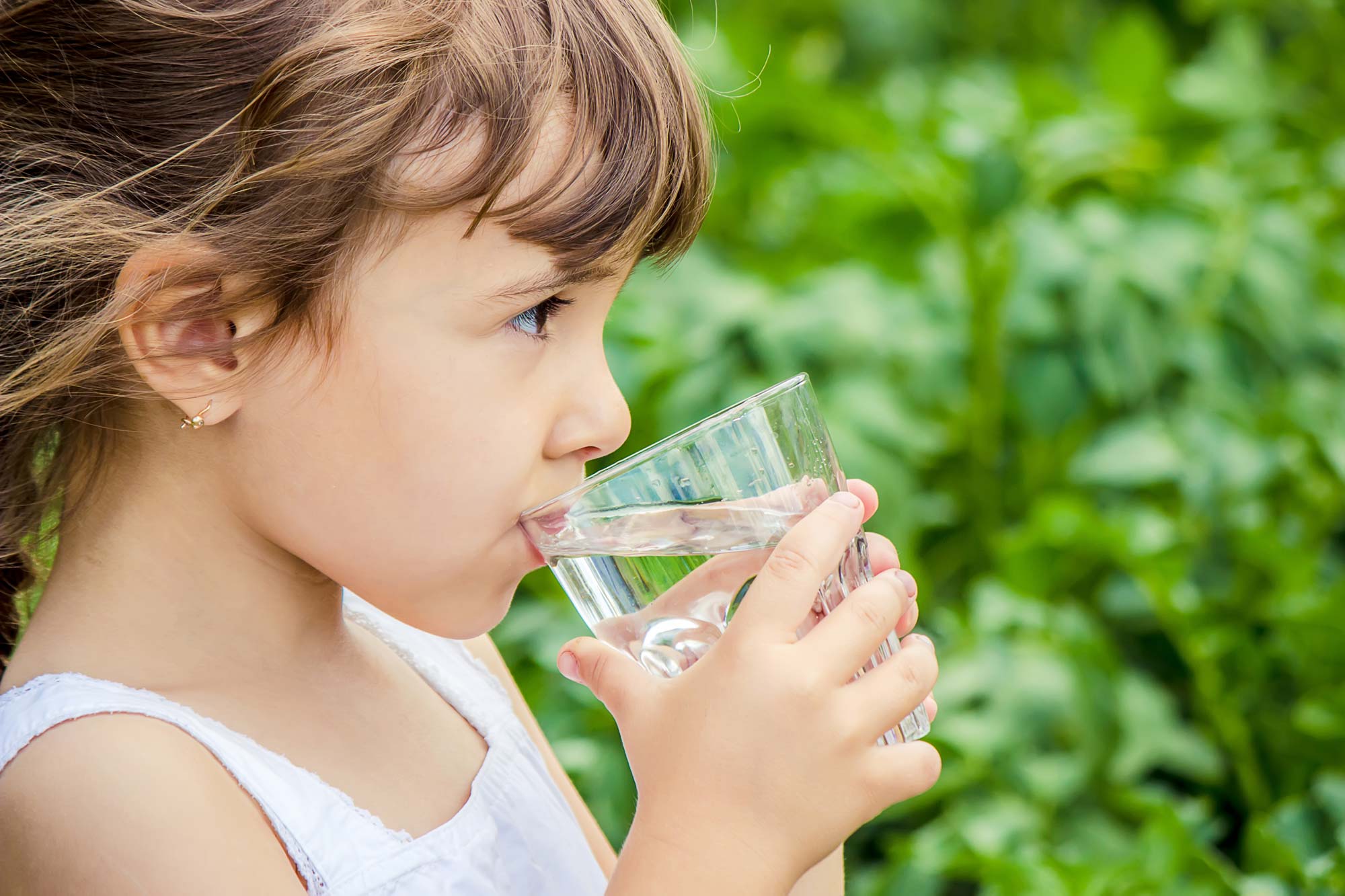 young girl drinking a glass of water